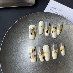Decorative nail art on a metallic surface with a blurred background