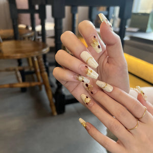Close-up of hands with decorative nail art in a casual setting