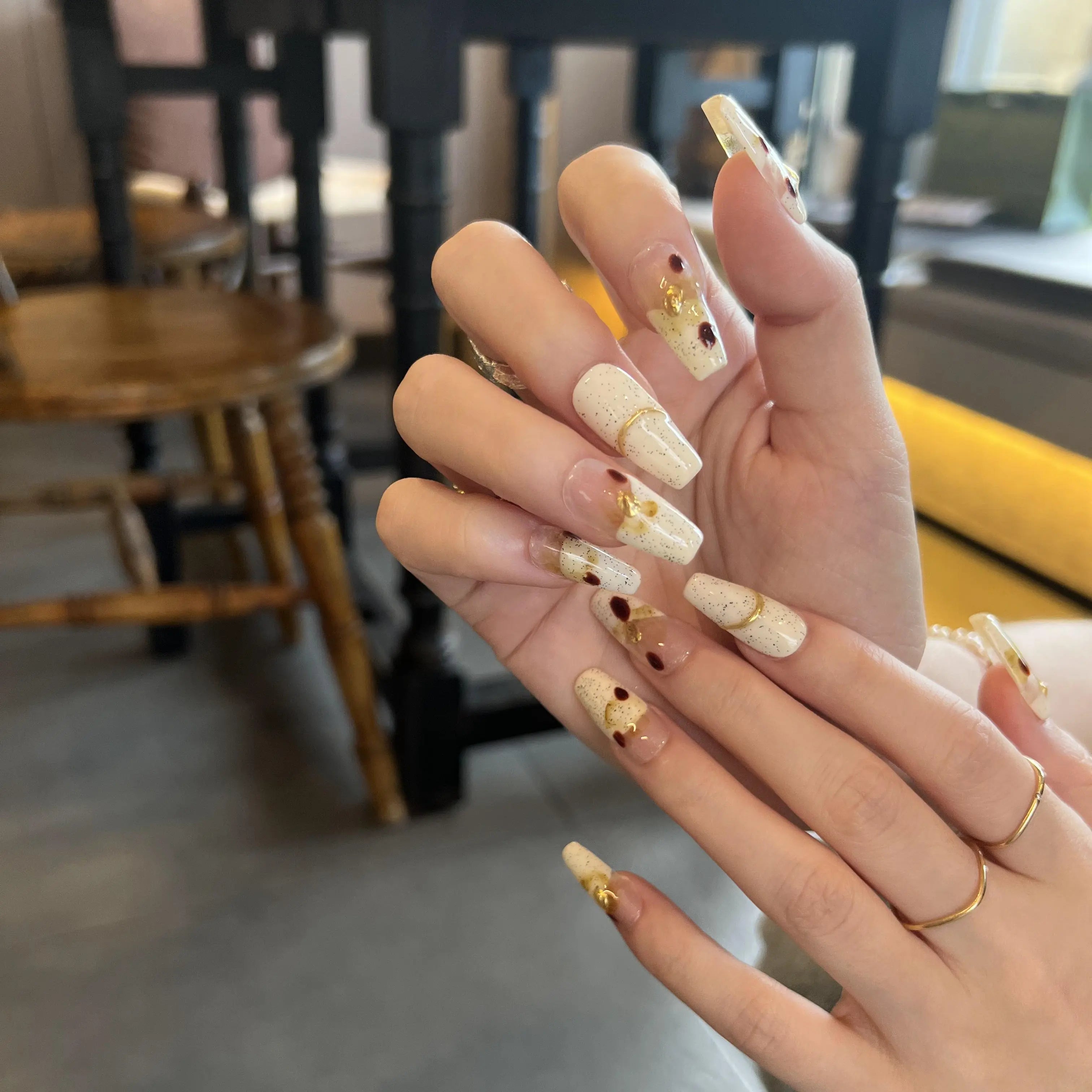 Close-up of hands with decorative nail art in a casual setting