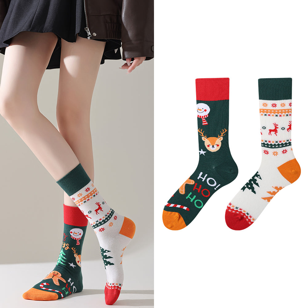 Person wearing festive patterned socks with Christmas designs, including reindeer and snowmen, on a plain background.