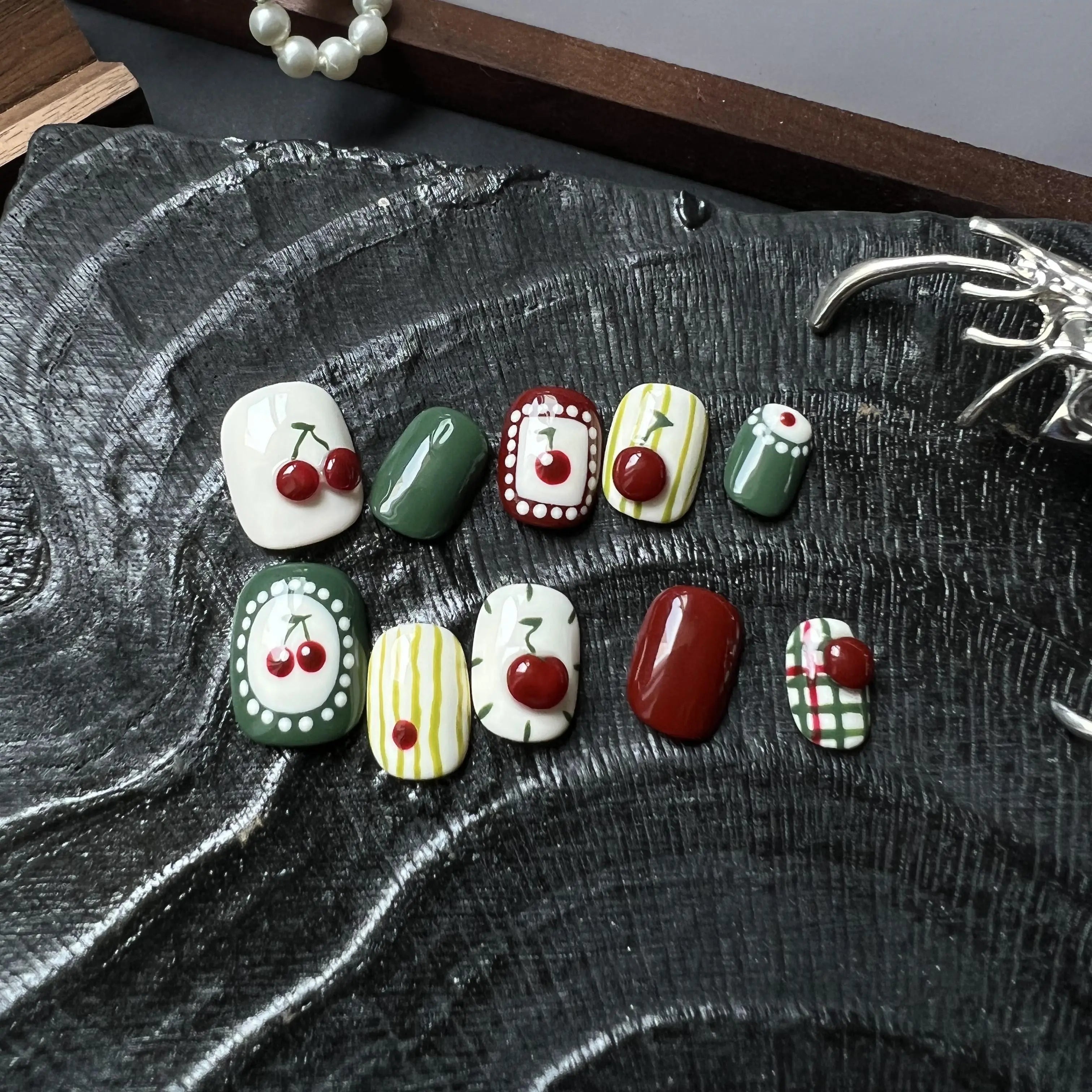 Set of decorative stones with cherry designs on a textured surface