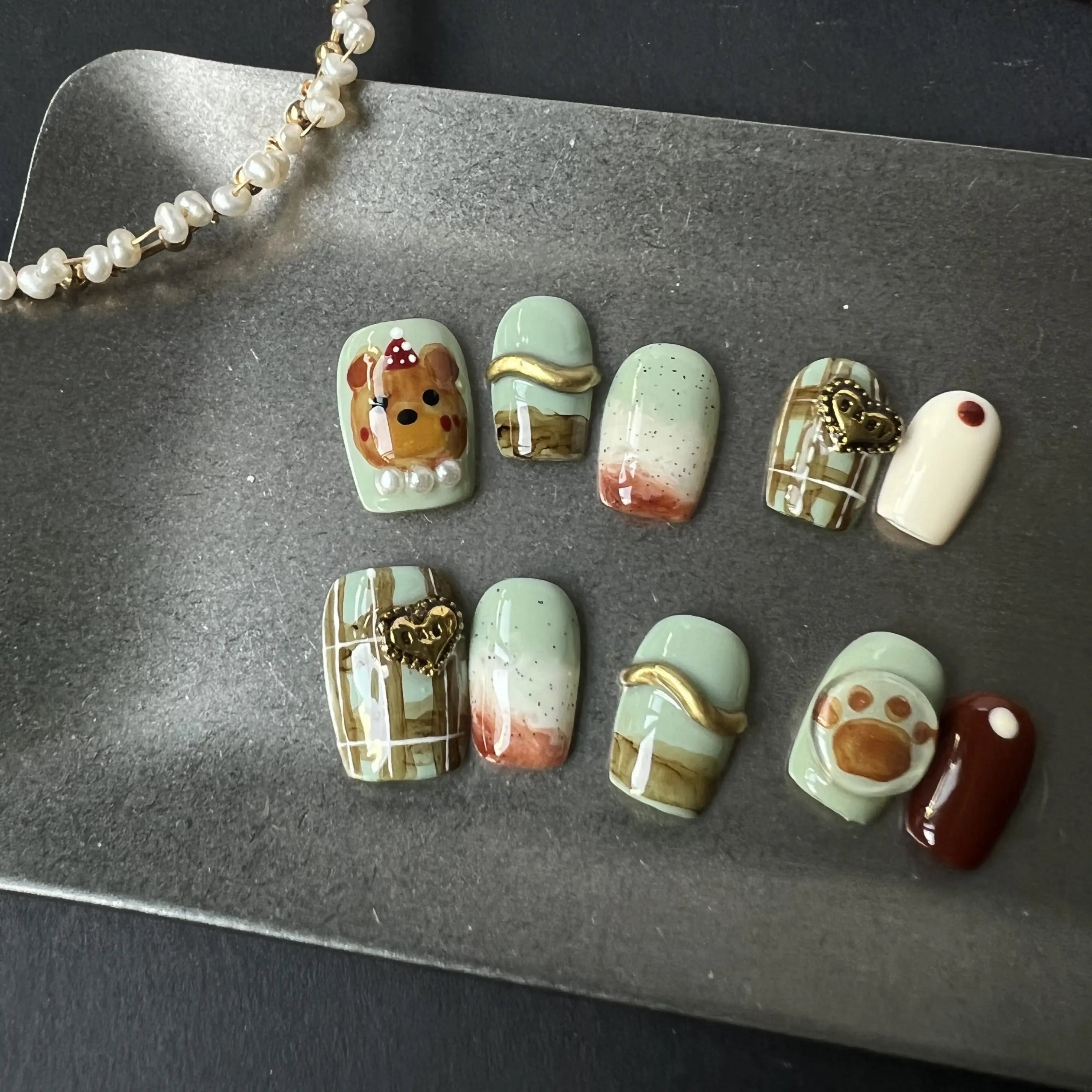 Set of decorative nail art designs on a metallic surface