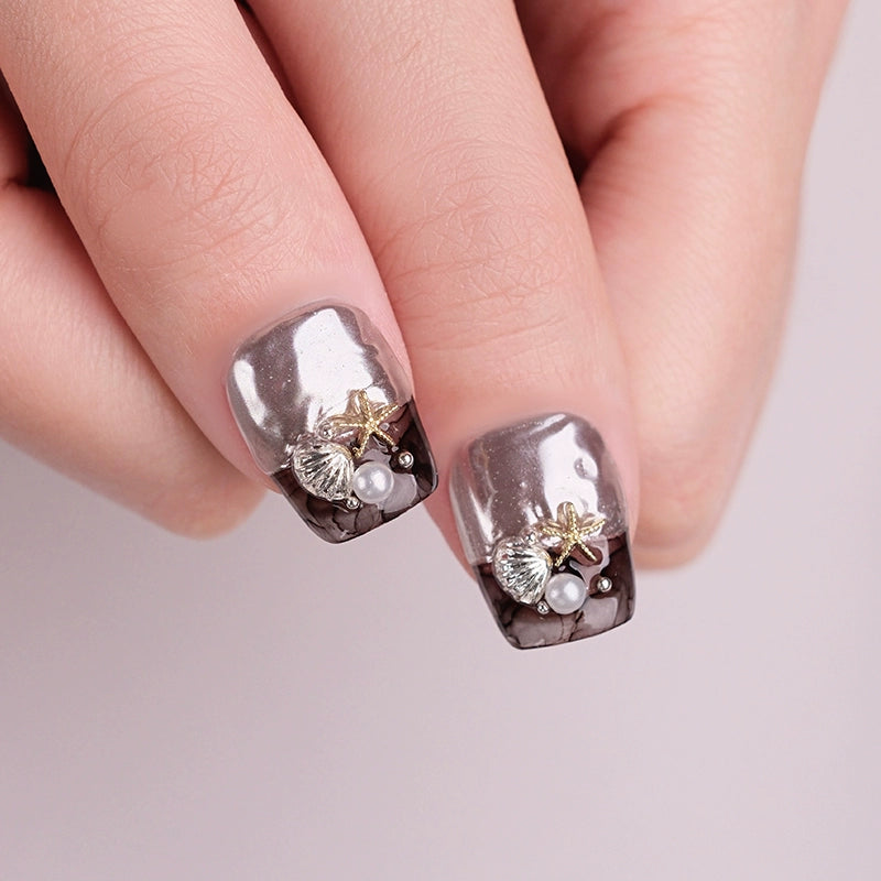 Nails with silver and gold design on a light pink background
