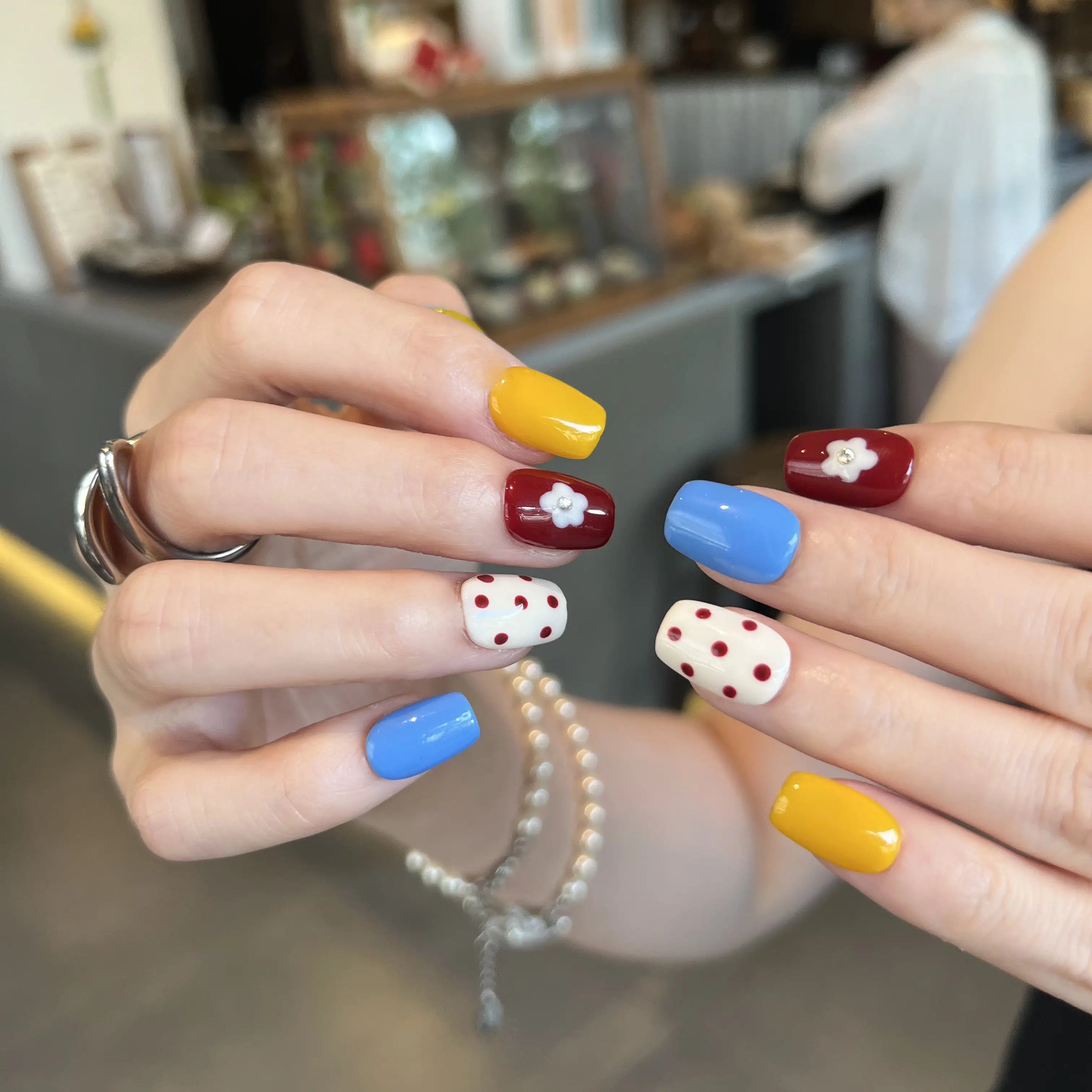 Close-up of hands with colorful nail designs in a casual setting