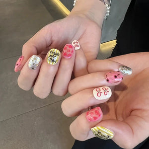 Hands with press on nails in pink, yellow, and silver glitter, featuring hand-drawn hearts, bows, and Hello Sunshine text.