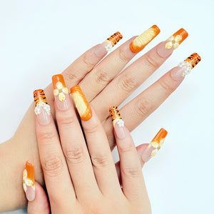 Set of orange 3D press on nails featuring handcrafted flowers and tiger stripe accents.