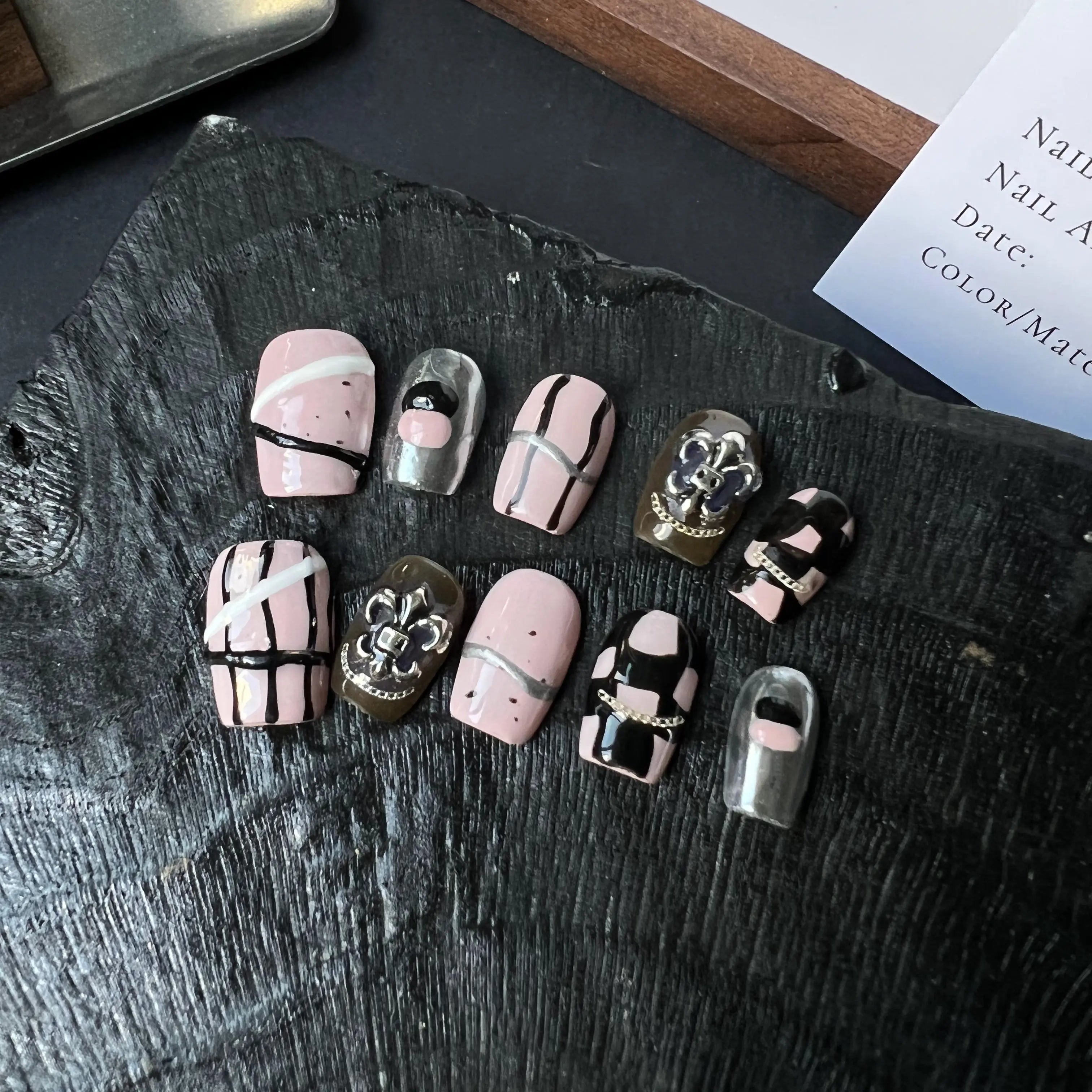 Collection of nail art designs on a dark stone surface